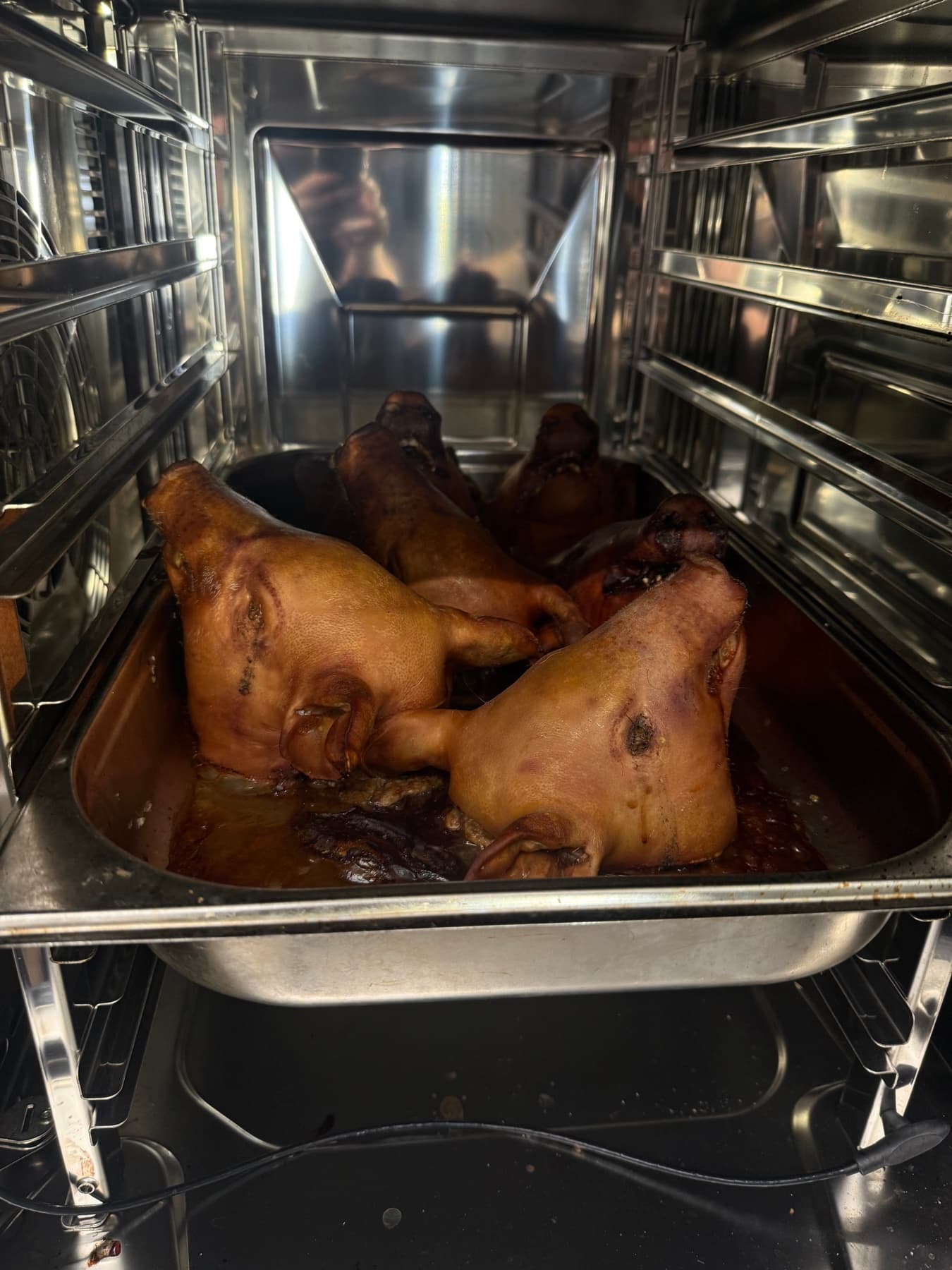 Cocción lenta de piezas de cerdo en una cocina profesional
